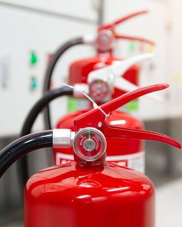 Drei Feuerlöscher hintereinander aufgereiht